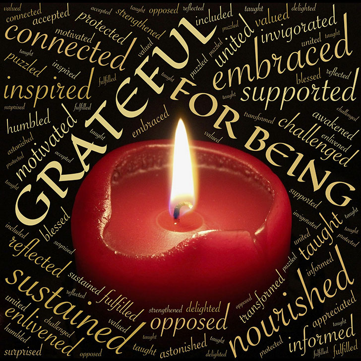 Candle with 'grateful' words around it